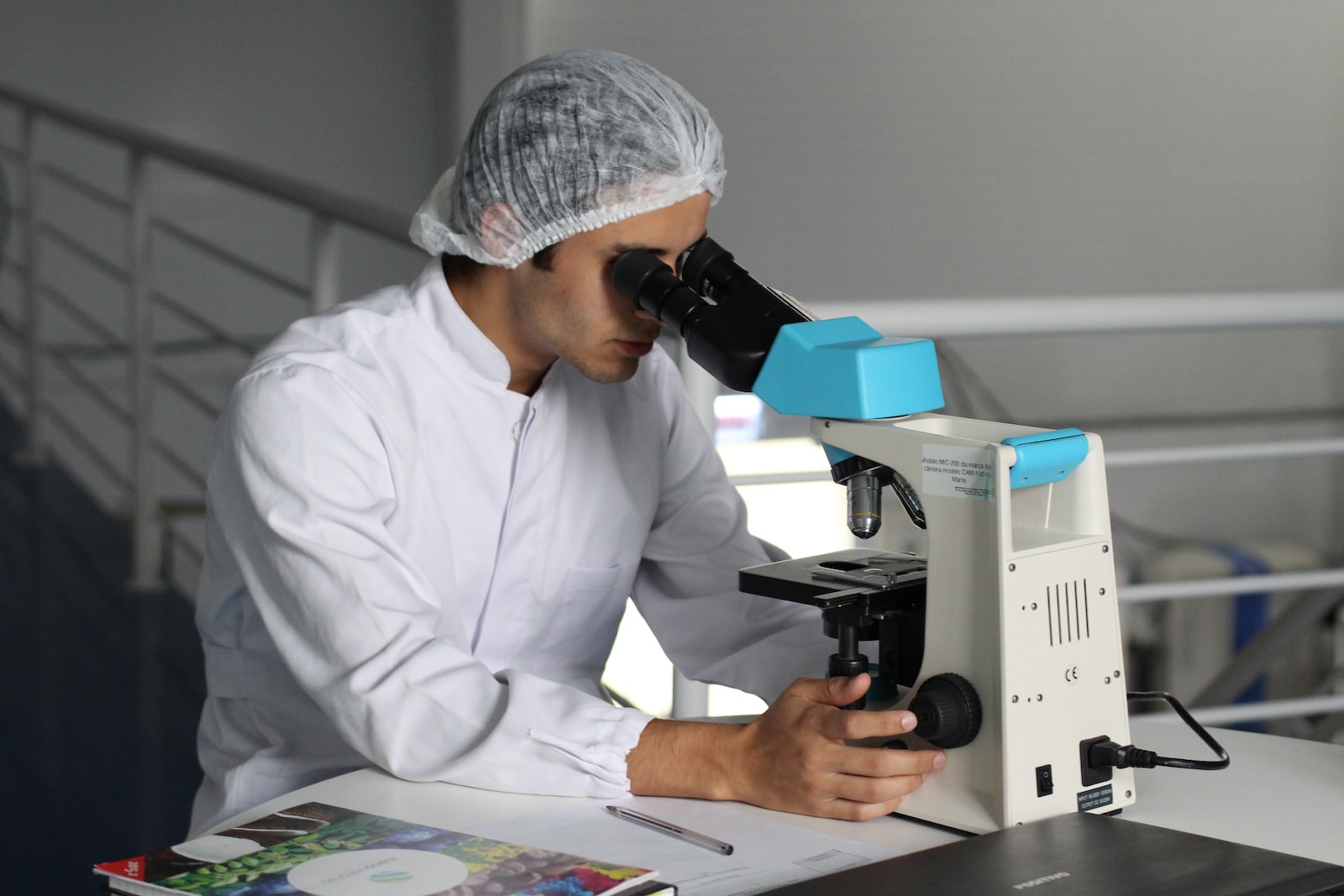 person in a laboratory looking through a microscope